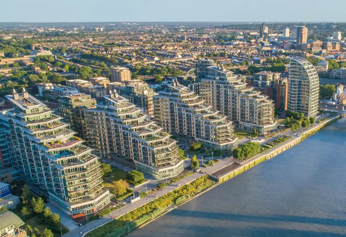 WarmRed Creative Aerial view of modern riverside apartment buildings and urban skyline under blue skies highlighting architectural design in a vibrant city waterfront setting