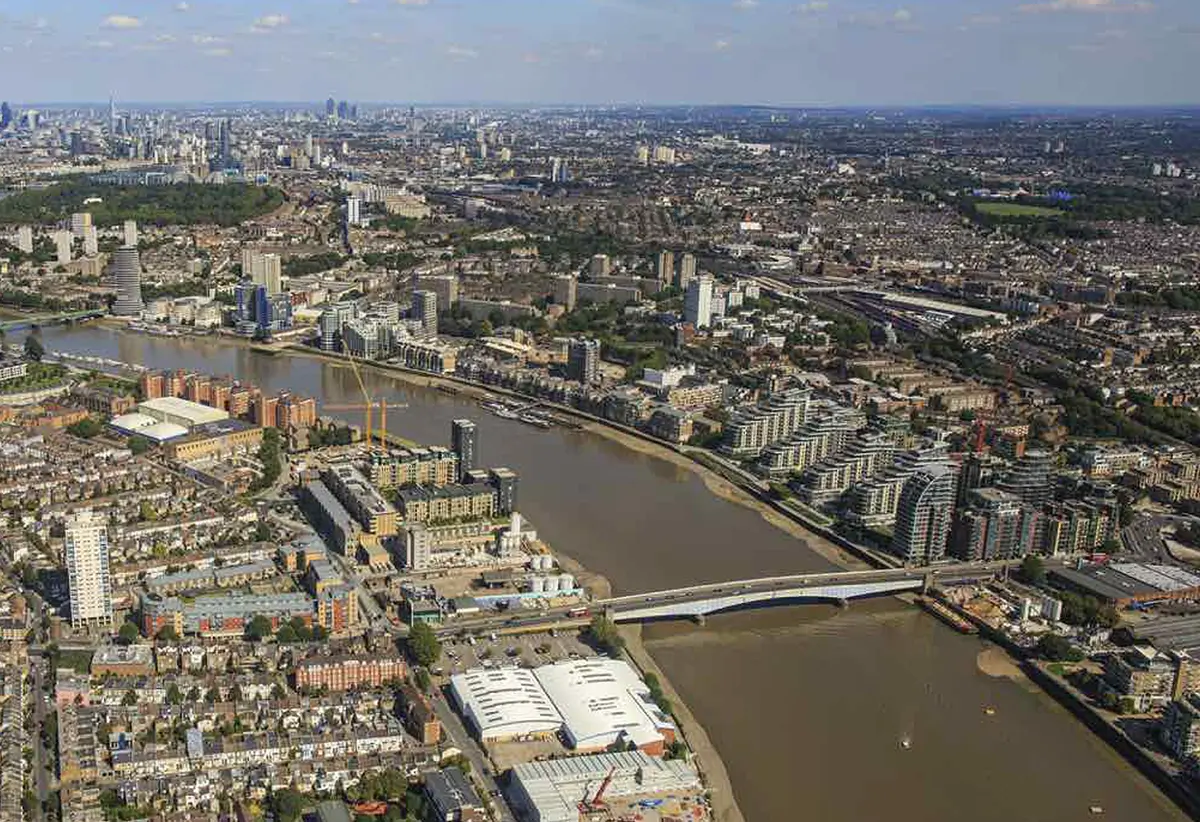 WarmRed Creative showcases a stunning aerial view of a cityscape with a winding river and numerous bridges surrounded by buildings under a clear blue sky.